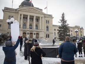 Attendees listen to a speech given during a solidarity protest and call to action is a protest being held at the Legislative Building.