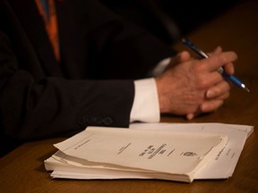 Une copie de la Loi constitutionnelle de 1982 se trouve à côté de Mitch McAdam, directeur de la Direction du droit constitutionnel, lors d'une conférence de presse.
