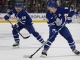 Toronto Maple Leafs forward Mitch Marner (16) controls the puck as defenceman Mark Giordano (55) trails the play against the Calgary Flames.