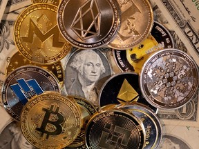 Representations of virtual cryptocurrencies are placed on U.S. dollar banknotes in this illustration taken Nov. 28.