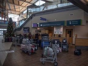 Bags are lined up in front of customer service at Regina International Airport where some delays and cancelations due to weather are stalling travel on Thursday, December 29, 2022 in Regina.