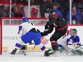 Canada's Connor Bedard, centre, scores the game-winning overtime goal against Slovakia on Monday night in Halifax.