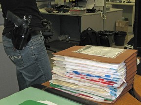 An armed officer with the Regina Integrated Drug Unit packs up and prepares to leave the office on Sept. 30 in preparation for the Project Faril takedown.