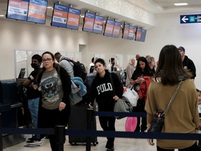 File foto penumpang dari maskapai penerbangan Sunwing berbaris untuk check-in di Bandara Internasional Cancun setelah banyak penerbangan ke Kanada dibatalkan.