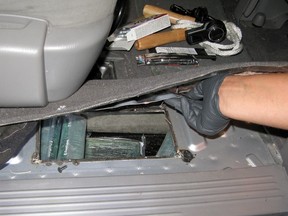 Members of the Regina Integrated Drug Unit reveal a hidden compartment while investigating a seized van in Vernon, B.C. on Saturday, Oct. 1, 2011.