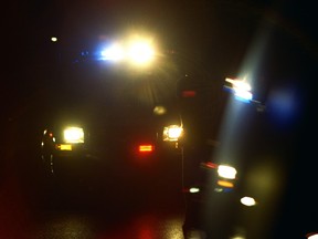 Emergency lights on RCMP vehicles light up the scene of a high risk takedown on a street corner in Salmon Arm, B.C. on Saturday, Oct. 1, 2011.