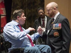 Minister of Veterans Affairs Kent Hehr speaks with veteran Brian McKenna, representing the 39 Brigade Group Wellbeing Network, at a stakeholder summit at the Canadian War Museum in Ottawa on Wednesday, Dec. 2, 2015.