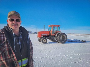 Garry Gibson stands with his 1987 Allis-Chalmers tractors used to prepare the race track for vintage snowmobiles. (Photo by Jennifer Argue, Local Initiative Reporter for the Last Mountain Times)