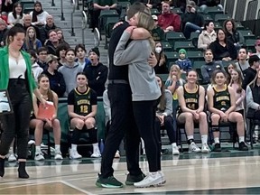 University of Regina Cougars women's basketball coach Dave Taylor hugs Madeleine Tell on Saturday at the Centre for Kinesiology, Health and Sport.