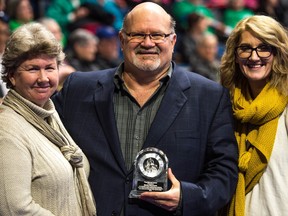 Veteran Leader-Post sports writer Murray McCormick, centre, received a Paul McLean Award during the Tim Hortons Brier being held at the Brandt Centre in Regina. He can be seen here at ice level with his wife Marian, left, and daughter Mallory, right.