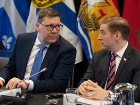 Saskatchewan Premier Scott Moe (left) speaks with Newfoundland and Labrador Premier Andrew Furey as they wait to start a meeting of Canada's premiers, Tuesday, February 7.