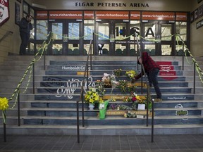 (FILE) A man drops off flowers at a memorial located inside the Elgar Petersen Arena in Humboldt on Saturday, April 7, 2018. (Saskatoon StarPhoenix/Kayle Neis)