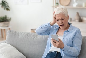 Mobile Scams Concept. Shocked Senior Woman Looking At Smartphone Screen In Frustration
