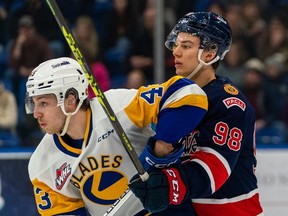 Regina Pats captain Connor Bedard (98) gets an elbow near his face from Saskatoon Blades winger Justin Lies during WHL action Sunday, March 19 at SaskTel Centre in Saskatoon.