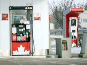 An electric vehicle charging station, right, along with a conventional gas pump, left, at a service station on Wednesday, March 8, 2023 in Regina.