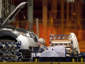 A line worker works on a car at Ford Motor plant in Oakville, Ont., on Friday, January 4, 2013.&ampnbsp;Ford Motor Co. says it will invest $1.8 billion in its Oakville Assembly Complex to turn it into an electric vehicle production hub.&ampnbsp;THE CANADIAN PRESS/Chris Young