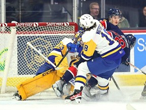 Saskatoon Blades Vaughn Watterodt checks Regina Pats captain Connor Bedard in close of the net and Blades goalie Ethan Chadwick in Western Hockey League Eastern Conference playoff action on Tuesday, April 4 at the Brandt Centre in Regina. (Photo by Keith Hershmiller)