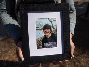 Aunt Rebecca BigEagle holds a photo of 16-year-old Dendrae Thunder Lonechild, who was struck and killed by a vehicle Sunday while walking in the Cathedral neighbourhood, in Regina.