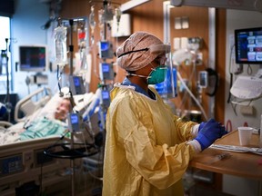 An intensive care unit health-care worker cares for a patient in a Toronto hospital in December of 2020.