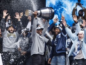Henoc Muamba, the Grey Cup MVP of the Toronto Argonauts hoists the Grey Cup trophy as he celebrates during a rally alongside teammates, staff, and fans in downtown Toronto, Thursday, Nov. 23, 2022. The Grey Cup-champion Toronto Argonauts were among four teams that exceeded the CFL's salary cap last season, the league announced Friday.
