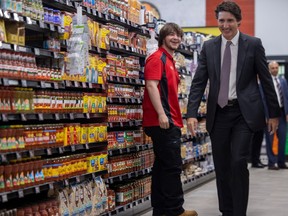 Co-op employee Haskel Looker smiles after a surprise meeting with Prime Minister Justin Trudeau during a planned media event at the Harbour Landing Co-op during during a visit to the province while announcing a federal grocery rebate that is connected with the Budget 2023 on Thursday, April 13, 2023 in Regina.