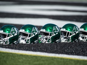 Roughrider helmets are lined up on the turf during training camp