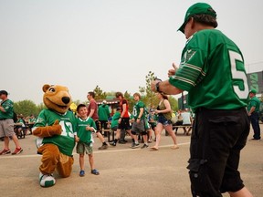 A spectator and Saskatchewan Roughriders mascot Gainer the Gopher on Saturday.