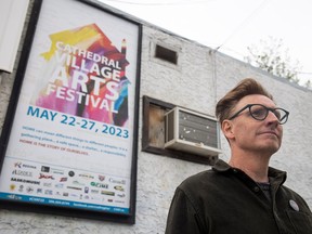 Cam Fraser, Cathedral Village Arts Festival planning committee chair, stands for a portrait in front of this year's poster that hangs on 13th Avenue on Thursday, May 18, 2023 in Regina.