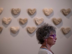 Saskatchewan artist Cheryl Ring stands in front of her project The Heart Spirits Project during the opening inside the Saskatchewan Legislative Building on Friday, May 5, 2023 in Regina. The art exhibit contains 200 handmade clay hearts; each in honour of an Indigenous person who is missing or was murdered.
