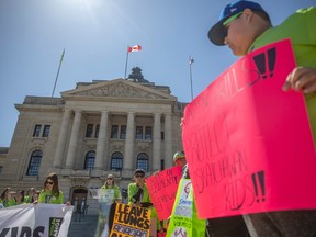 Youth wave anti-vaping signs in front of the Sask. legislative building.