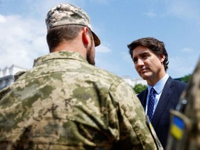 Canadian Prime Minister Justin Trudeau speaks with Ukrainian soldiers as he visits an exhibition of destroyed military vehicles in Kyiv on June 10, 2023, amid Russia's invasion of Ukraine.