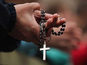 A woman holds rosary beads in March of 2013 in Vatican City, Vatican.