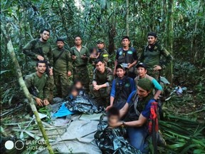 In this handout picture released by the Colombian presidency on Friday, June 9, 2023, members the army pose with four Indigenous children after the kids spent more than a month lost in the Amazon rainforest following a plane crash.