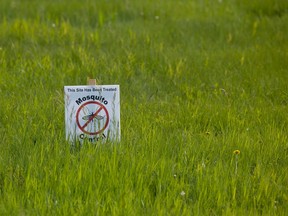 A sign warning residents that grassy areas have been sprayed with pesticides in Regina.
