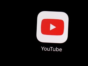 This March 20, 2018, file photo shows the YouTube app on an iPad in Baltimore. Quebec police say they have arrested a social media influencer who allegedly committed fake crimes in an effort to gain popularity.