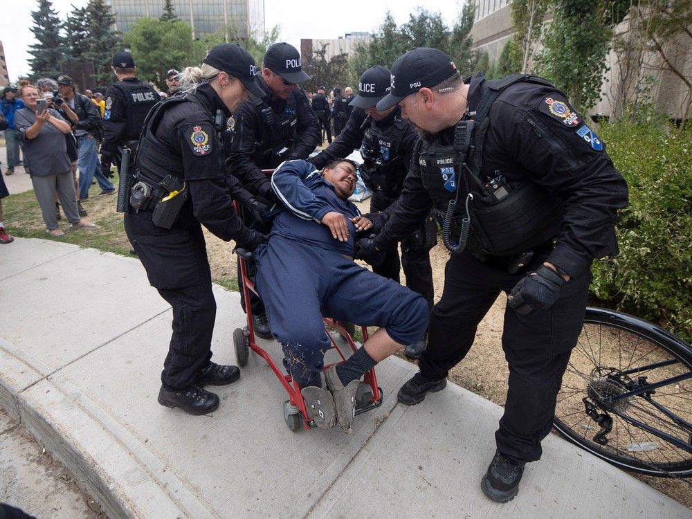 Regina Police Service move a camp member at Regina City Hall on Friday, July 28, 2023.