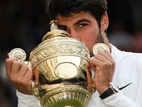 Carlos Alcaraz kisses the winner's trophy after beating Novak Djokovic in the Wimbledon final at The All England Tennis Club in Wimbledon on July 16, 2023.