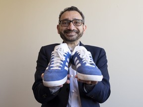 Transport Minister Omar Alghabra holds up a pair of his Adidas shoes as he poses for a photo in Ottawa on Thursday, June 22, 2023.