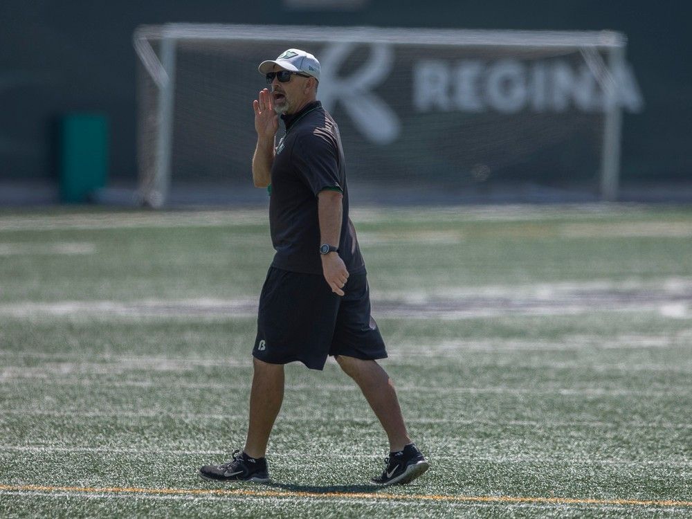 Saskatchewan Roughriders head coach Craig Dickenson walks on field during practice at Mosaic Stadium.