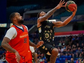 Saskatchewan Rattlers guard Justin Wright-Foreman, right, lays up the basketball as Vancouver Bandits forward Nick Ward, left, looks on during CEBL action at SaskTel Centre in Saskatoon last week.
