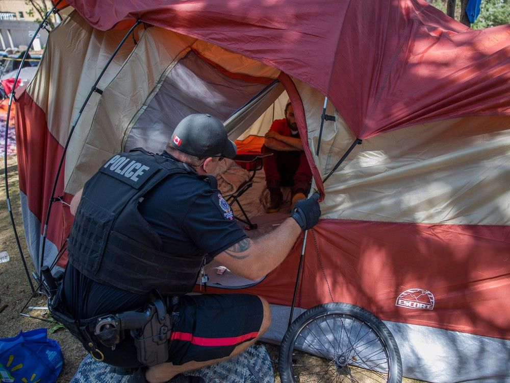 A member of the Regina Police Services informs camp members that they need to be vacated from City Hall in the next 24 hours, as work to dismantle the pop-up encampment of as many as 85 tents begins on Thursday, July 27, 2023 in Regina.