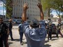 A man throws his hands in the air in front of the Regina Police Service, as camp members are told that they need to be vacated from City Hall in the next 24 hours on July 27, 2023, as a push to dismantle the pop-up encampment thats has held around eighty-five tents since it gathered in June.