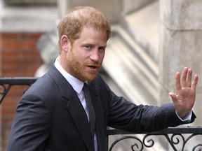 FILE - Britain's Prince Harry salutes media as he arrives at the Royal Courts of Justice in London, on March 30, 2023. Prince Harry is expected to return to the U.K. next month to attend a charity awards ceremony on the eve of the first anniversary of Queen Elizabeth II's death.