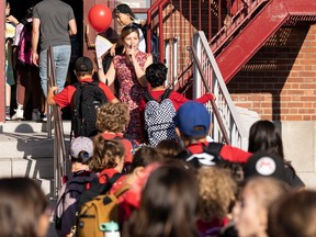 Grade three teacher Catherine Rioux-Tache leads her students into class at Sainte-Cecile elementary school on their first day back to school in Montreal, Monday, Aug. 28, 2023. THE CANADIAN PRESS/Christinne Muschi