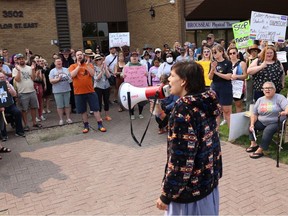 The crowd of an estimated 400 people encircled a speaker during a large protest Sunday, August. 27 in Saskatoon outside the office of MLA Don Morgan. The protestors were speaking out against a new Saskatchewan government policy requiring schools to seek parental consent when a student under 16 wants to change their name or pronoun. ROB O'FLANAGAN/SASKATOON STARPHOENIX