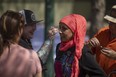 Actor and creator Zarqa Nawaz (C) receives a makeup touchup before a scene on set of the TV series ZARQA being filmed on Edgar street on Tuesday, May 9, 2023 in Regina. KAYLE NEIS / Regina Leader-Post