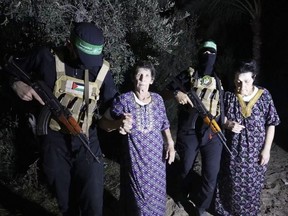 Yocheved Lifshitz, 85, center, and Nurit Cooper, 79, are escorted by Hamas as they are released to the Red Cross in an unknown location, Oct. 23, 2023.