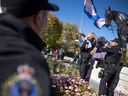 Miki Mappin holds a transgender flag as she is carried off a statue of the queen by members of the Regina Police Service during opposing rallies regarding the pronoun policy in school, a policy which was the subject of a court case and injunction mere weeks ago. Attendees gathered outside the Saskatchewan Legislative Building on Tuesday, Oct. 10, 2023 in Regina.