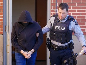 Michael MacKay, left, was escorted out of Battleford Courthouse by a RCMP officer after being convicted of second-degree murder of his wife Cindy MacKay in Battleford, Sask., Monday, Nov. 20, 2023.