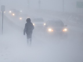A pedestrian braves the elements as high winds blow snow and obscure visibility along Clarence Avenue in Saskatoon in January of 2022.